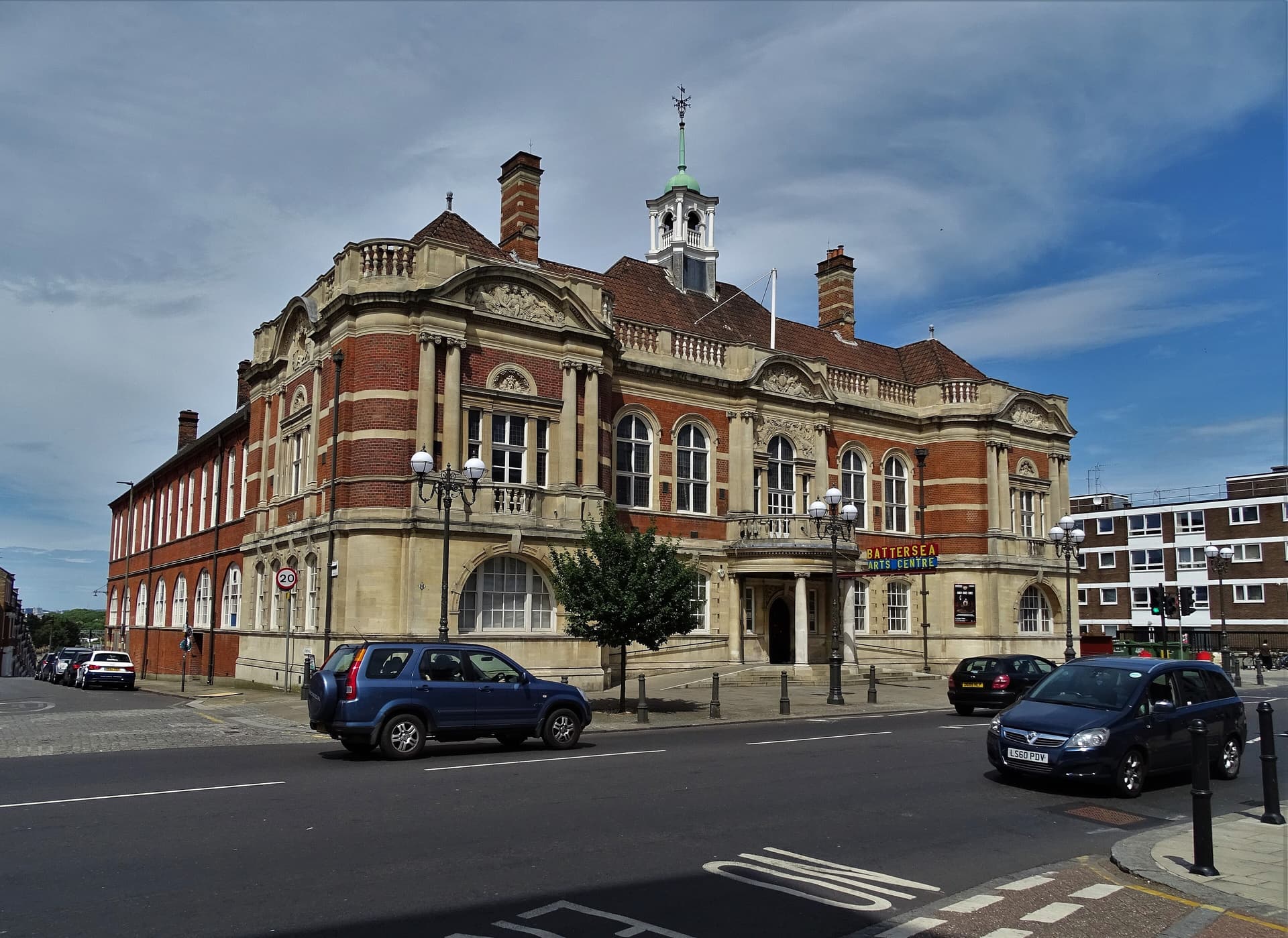 Red brick and stone Edwardian town hall with white cupola, now Battersea Arts Centre, seen from Lavender Hill under blue sky